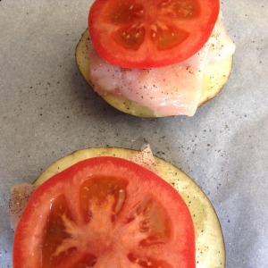 Chicken topped with fresh tomato slices. Ready to go into the oven!